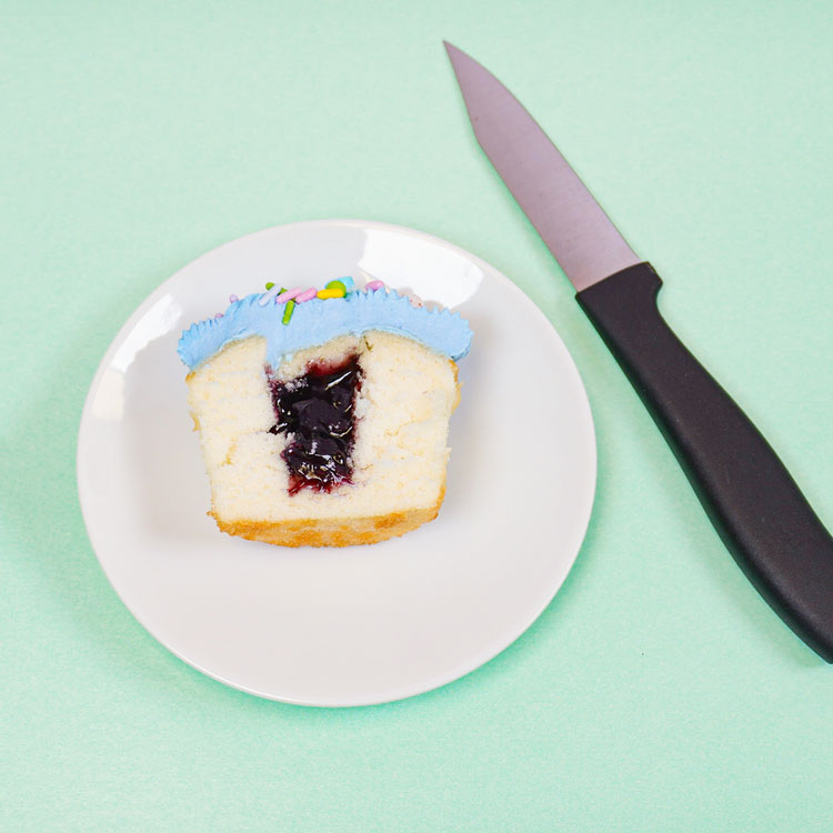 filled cupcake sitting next to paring knife