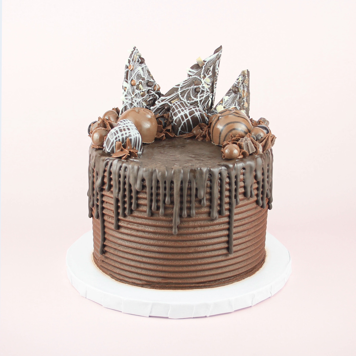 Chocolate cake embellished with chocolate buttercream, chocolate drip and chocolate handmade candies