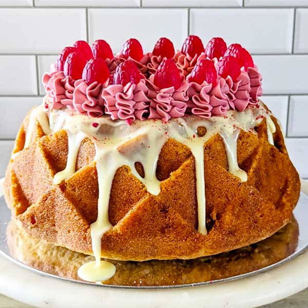 bundt cake topped with swirls and raspberries