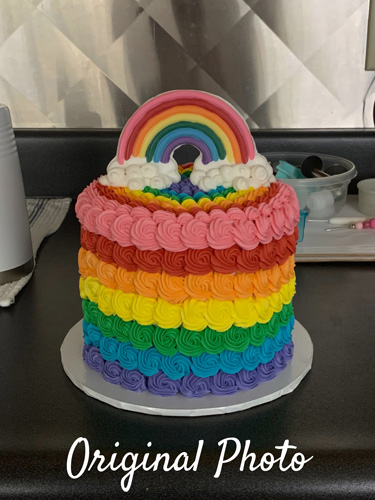photo of rainbow cake taken in kitchen with junk around it
