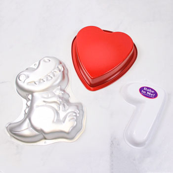 specialty shaped pans in shapes of dinosaur, heart, and number 7 