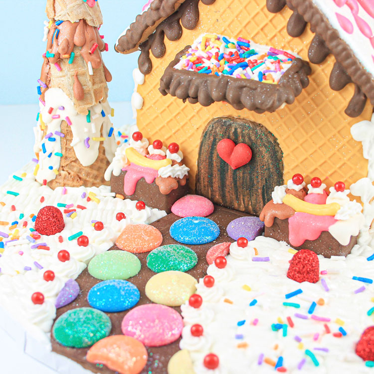 gingerbread house made out of ice cream sundae ingredients with melted ice cream roof