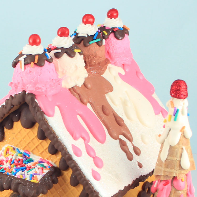 gingerbread house made out of ice cream sundae ingredients with melted ice cream roof