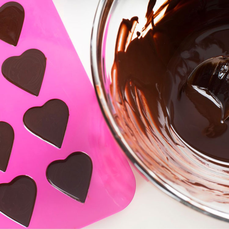 bowl of melted chocolate and chocolate mold filled with chocolate