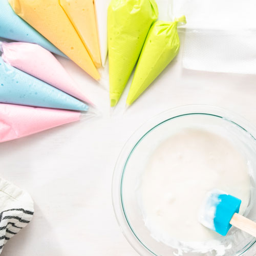 colored royal icing in piping bags ready for cookie decorating