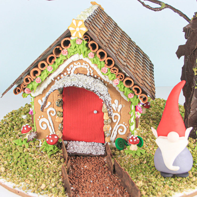 woodland inspired gingerbread house with gnome and chocolate accents