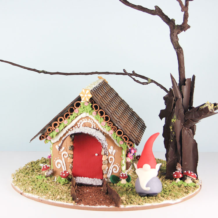 woodland inspired gingerbread house with gnome and chocolate accents