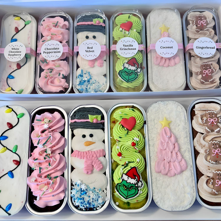 mini loaf cakes all decorated for christmas: pinks, Grinch, and more