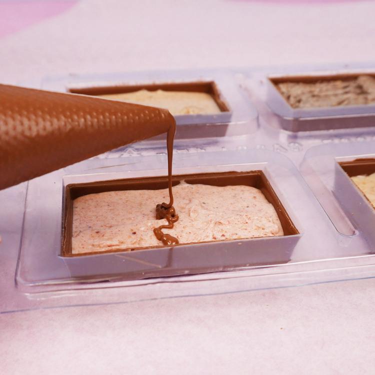 covering the top of the candy bar shell with chocolate