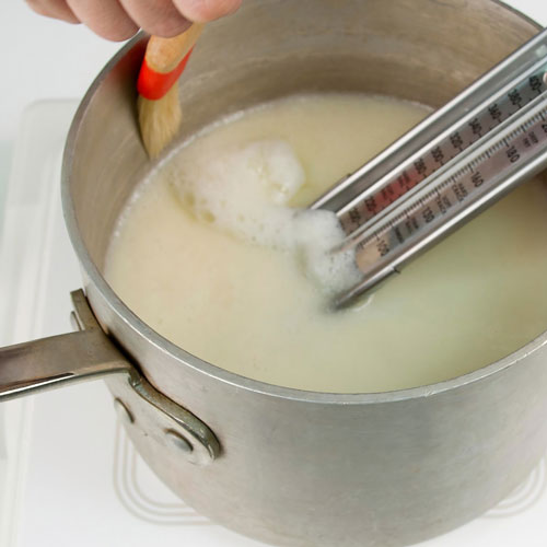 heavy bottom pot with candy boiling and being watched with candy thermometer