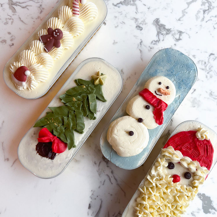 mini loaf cakes decorated like santa, snowman, tree, and gingerbread