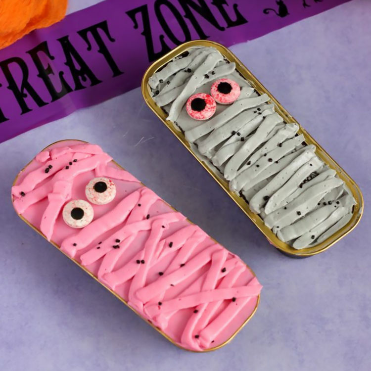 two mini cakes decorated to look like mummies