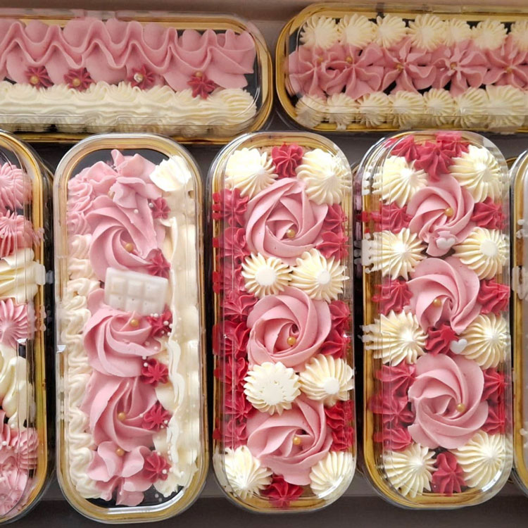 piped rosettes in pinks and whites on mini loaf cakes
