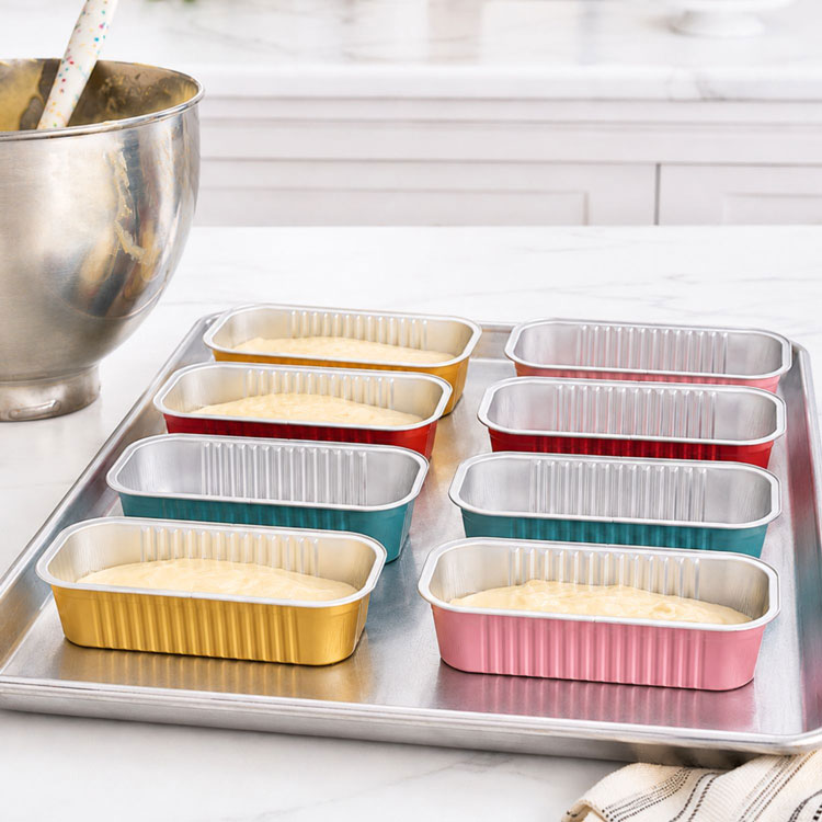 baker preparing mini loaf pans for baking