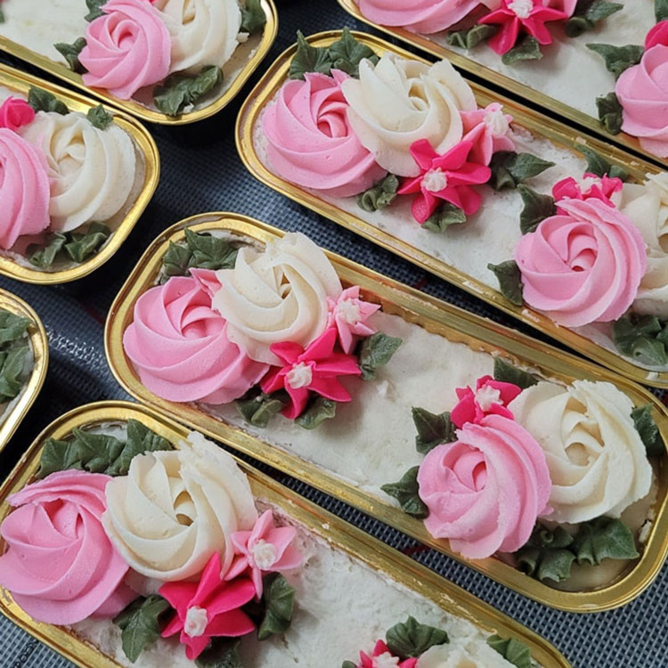 pink and white piped flowers on mini loaf cakes