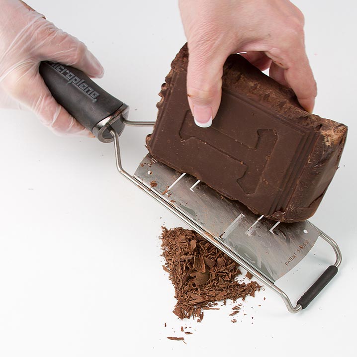  Firmly scrape the chocolate bar along the edge with a grater. 