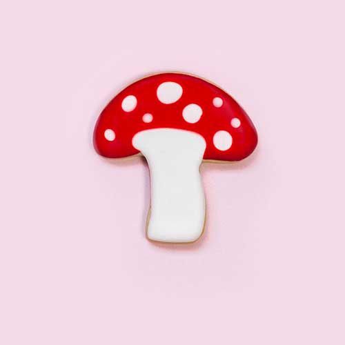 Red capped white polkda dotted mushroom cookie decorated in royal icing