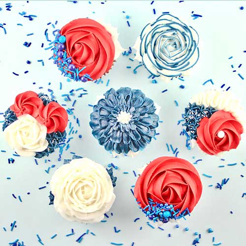 Buttercream Blooming Cupcakes in Red White and Blue rosettes, roses, stars and ribbons.