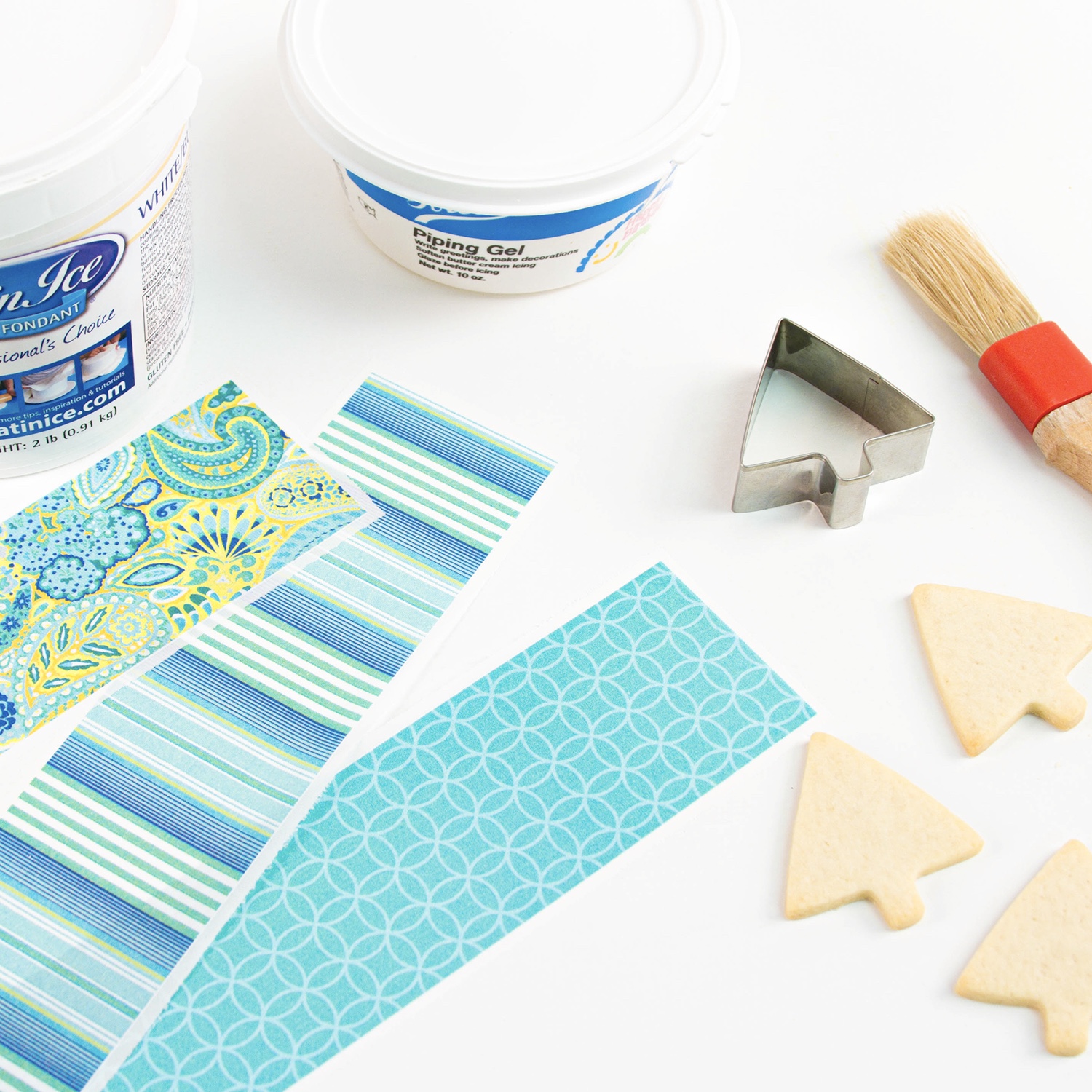 Image of tools used such as piping gel, fondant, edible images, cookie cutter and paint brush