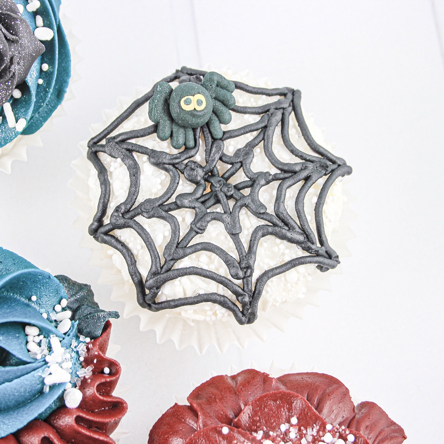 Spiders Web piped cupcake with a bed of white spinkles looking like spider eggs. 