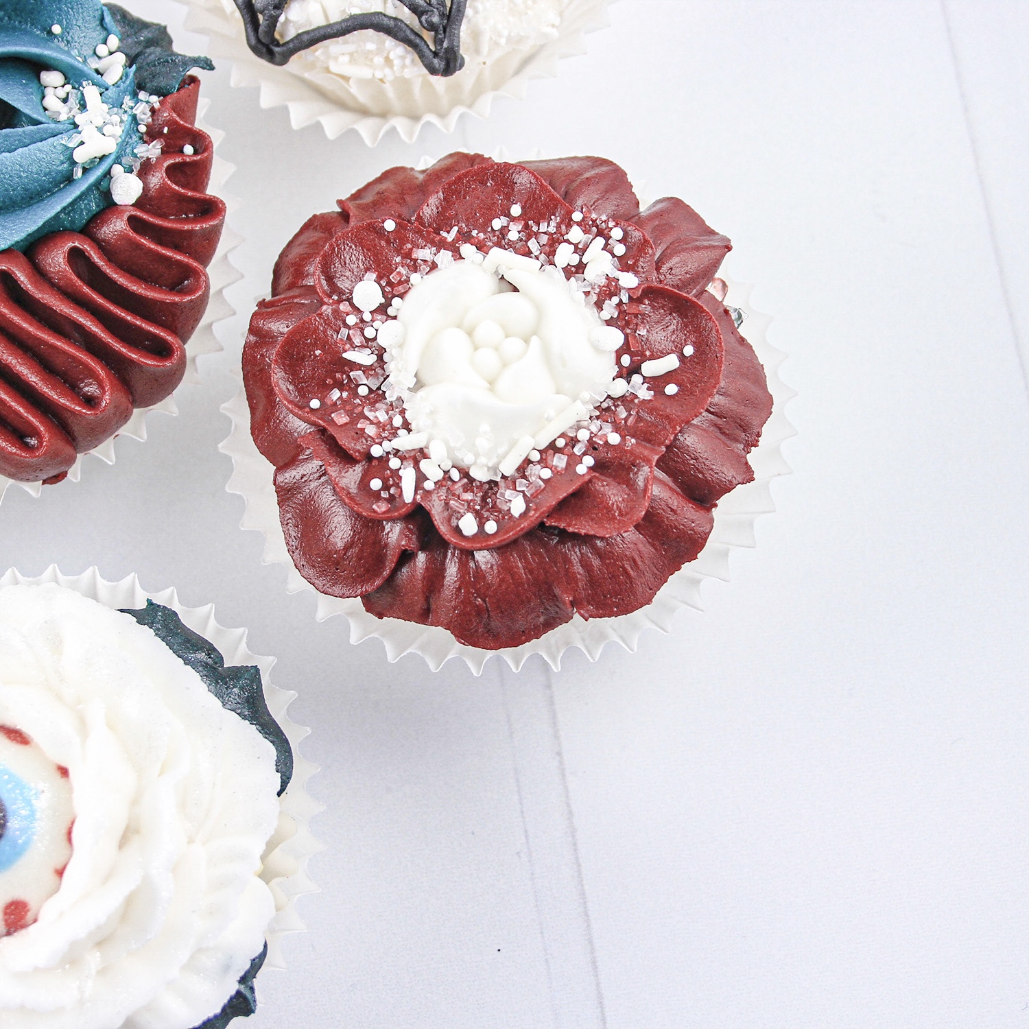 Red Rose Cupcake with a Russian Tip Rose center and white sprinkles of jimmies nonpareils, pearls and sugars