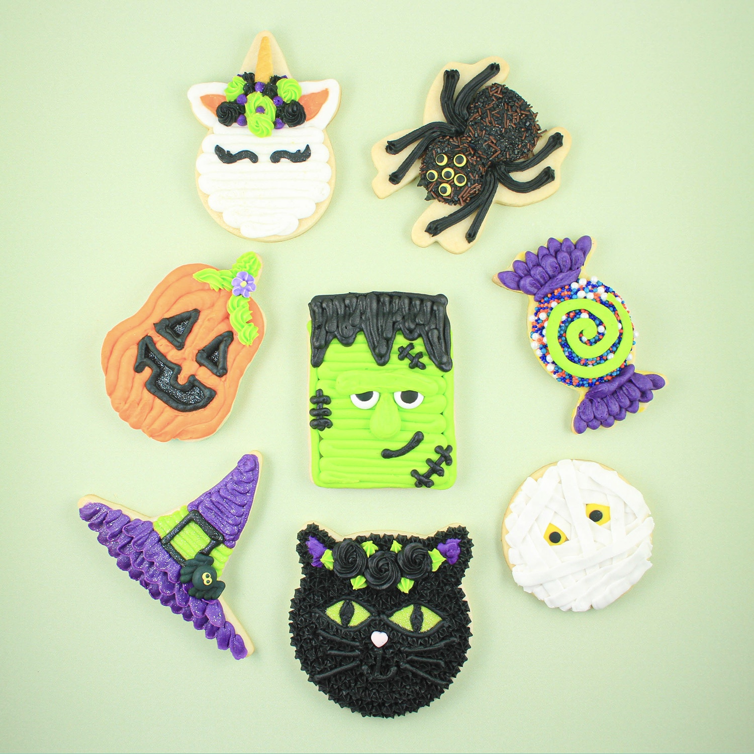 Buttercream Halloween Sugar Cookies, black cat with gold eyes, jack-o-lantern, mummy, frankenstein, unicorn, wrapped candy cookies