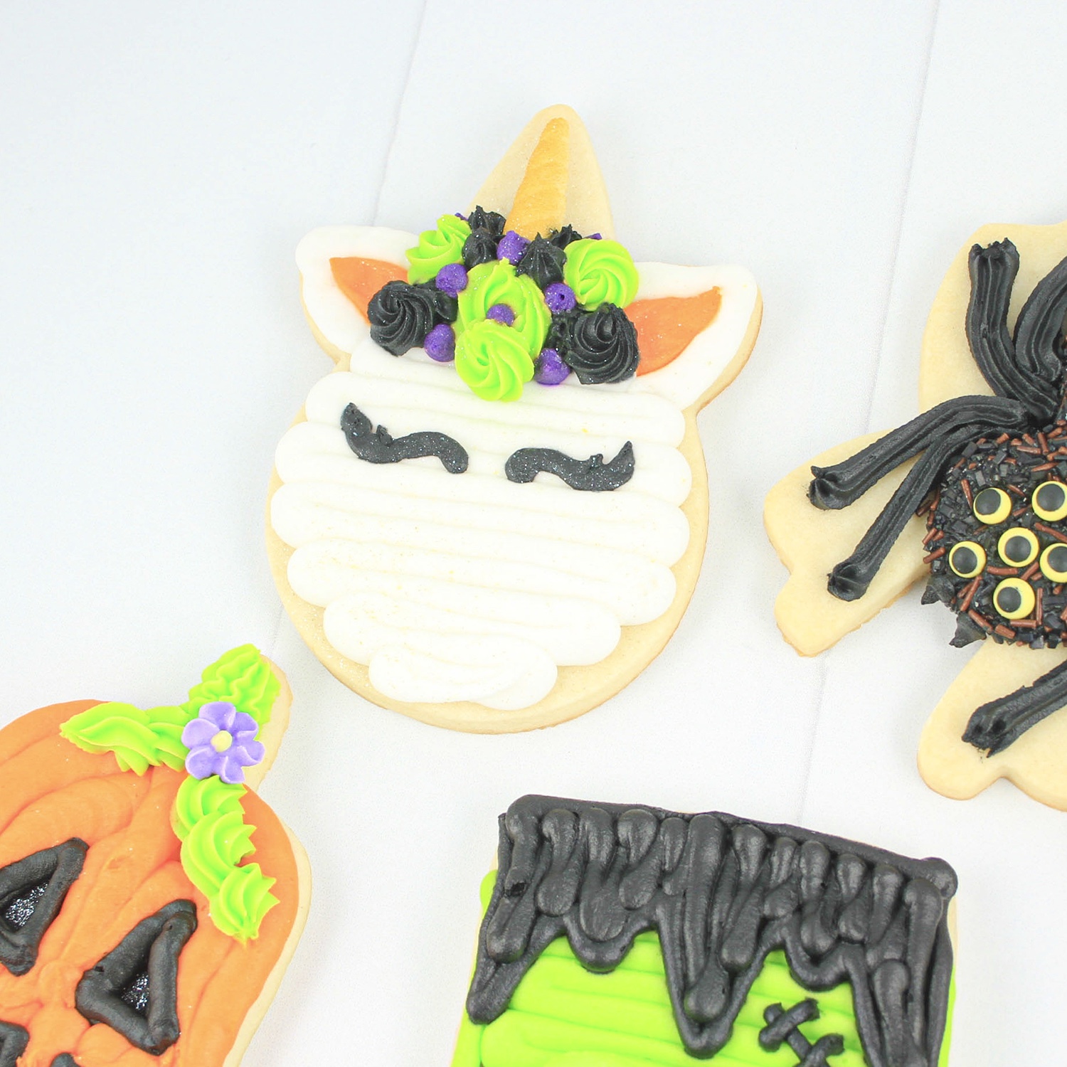 Halloween Unicorn cookie with black and green rosettes and purple star floral crown.