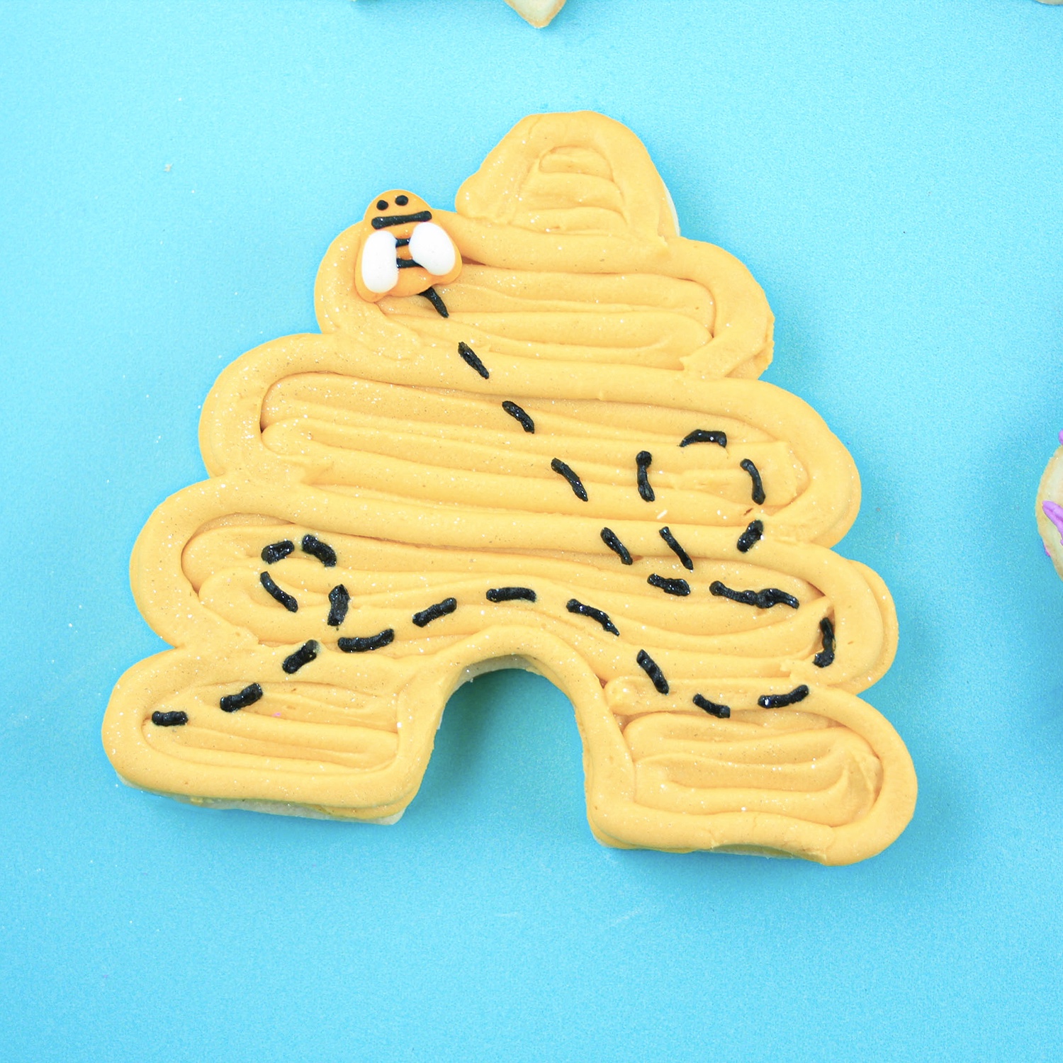 Bee hive buttercream decorated cookie with sugar bee layons