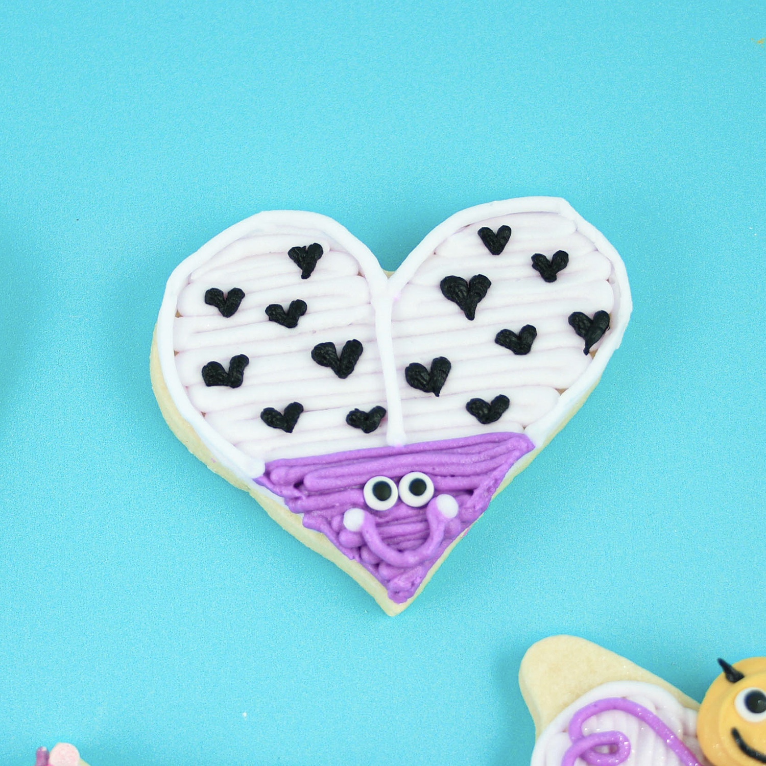 heart shaped lady bug decorated in purple and white buttercream and heart dots