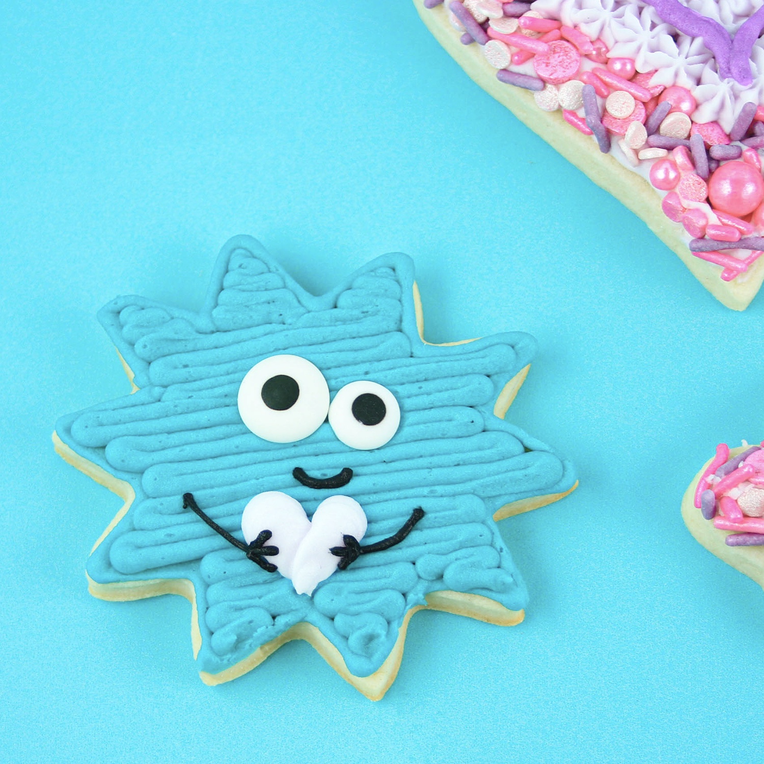 sunflower shaped cookie decorated in blue buttercream as a love bug