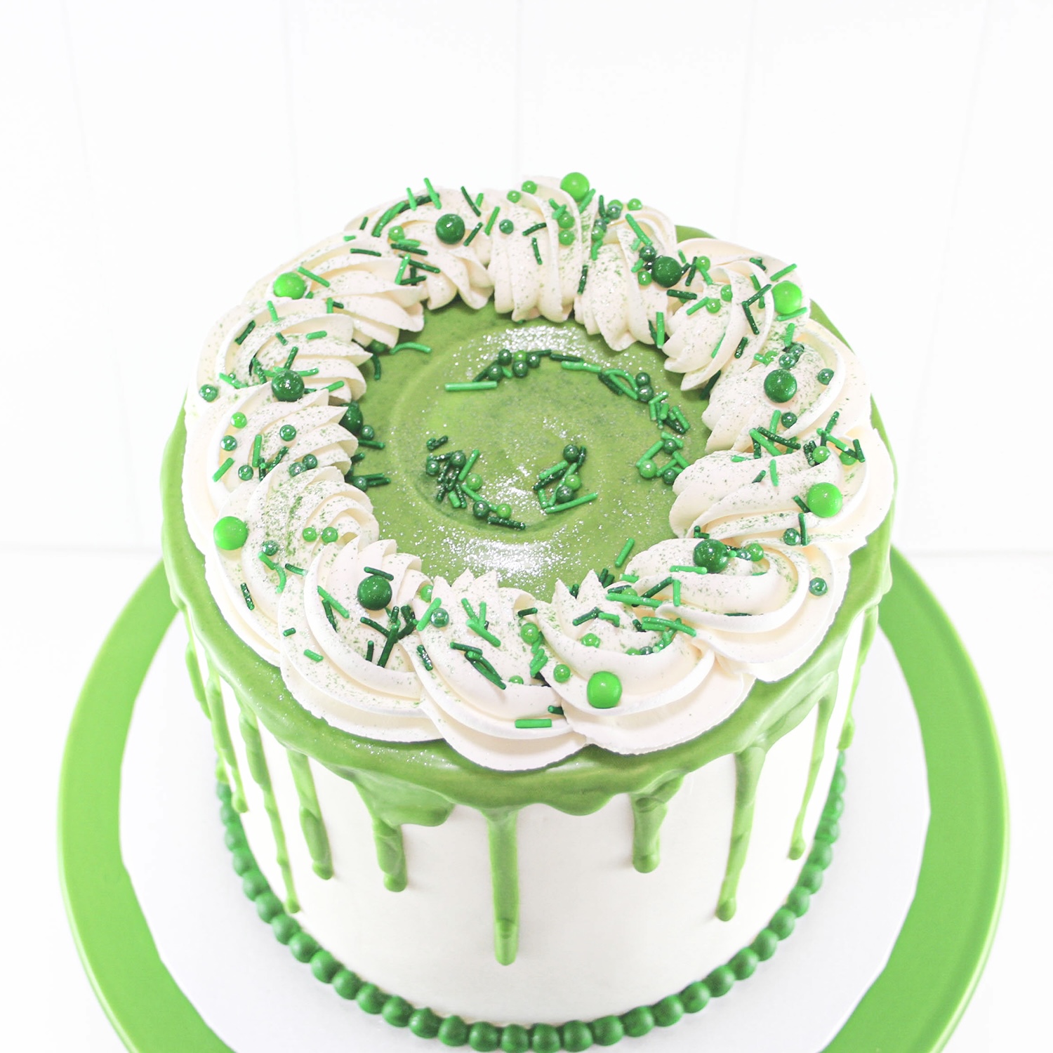 Green Drip Cake with piped rope border and green sprinkles