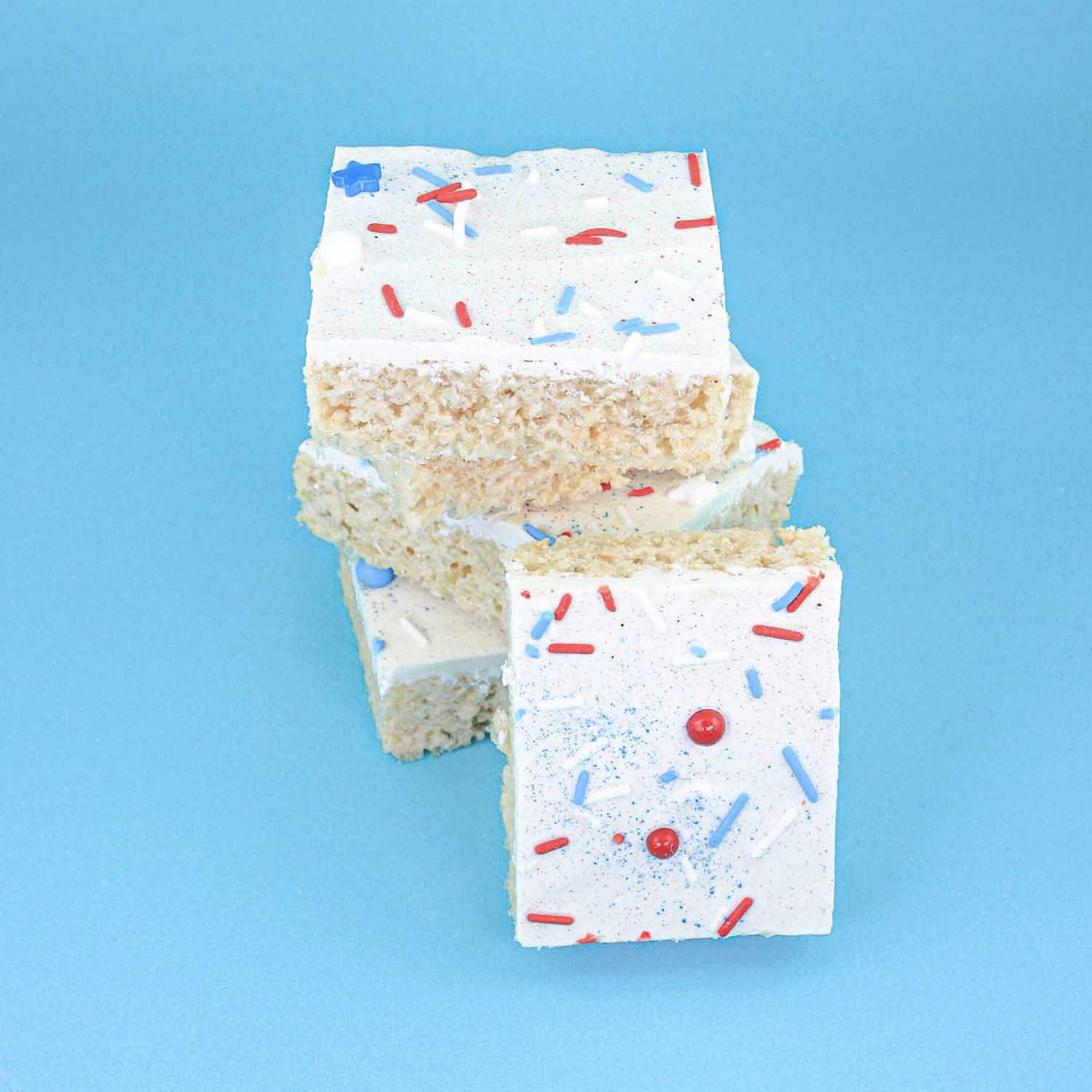 Rice krispie treat coated in white chocolate, patriotic spinkles of jimmies and stars and pearls, with jewel and diamond dust sparkle.