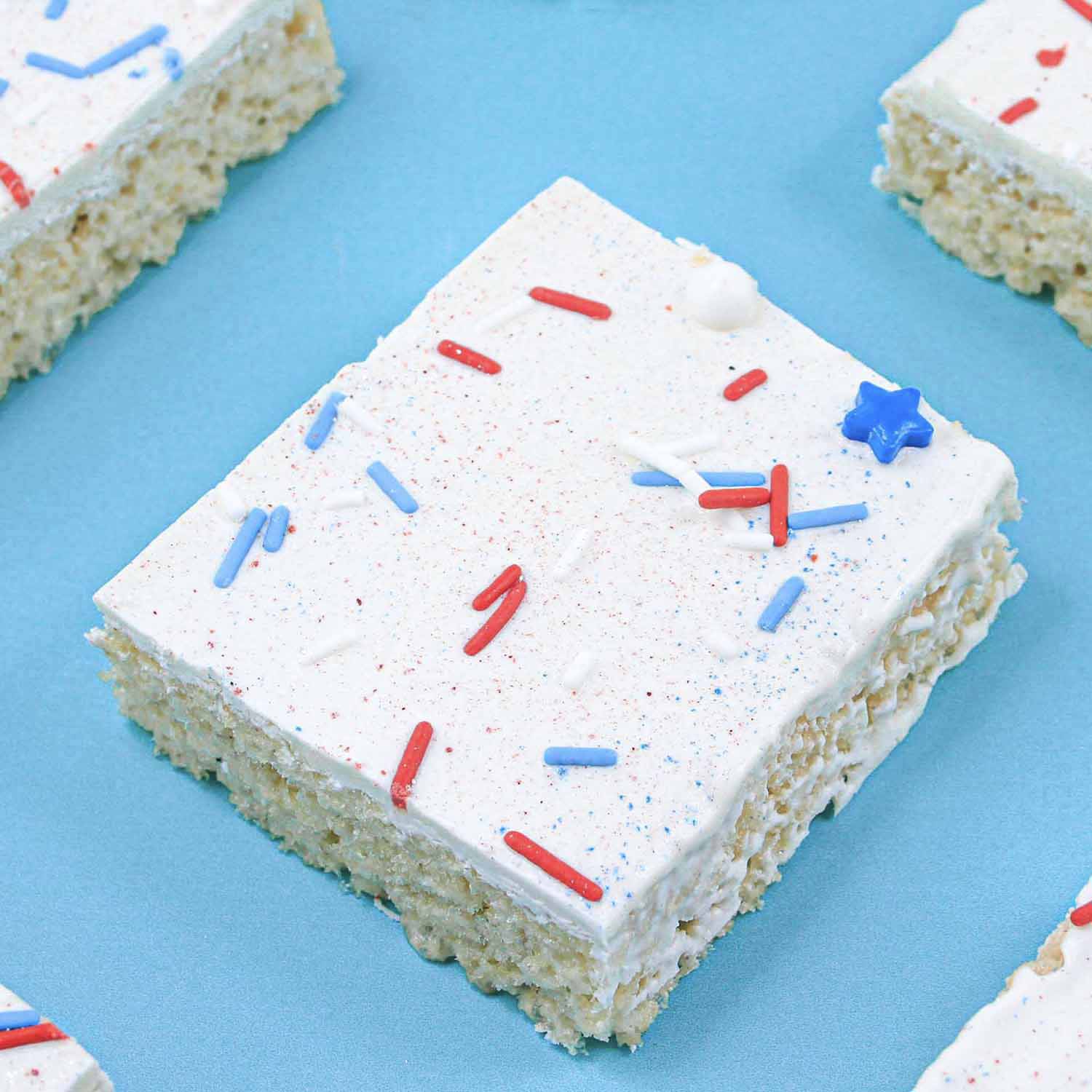 Single cut chocolate coated rice krispie treat topped with red white and blue sprinkles and jewel and diamond dusts.
