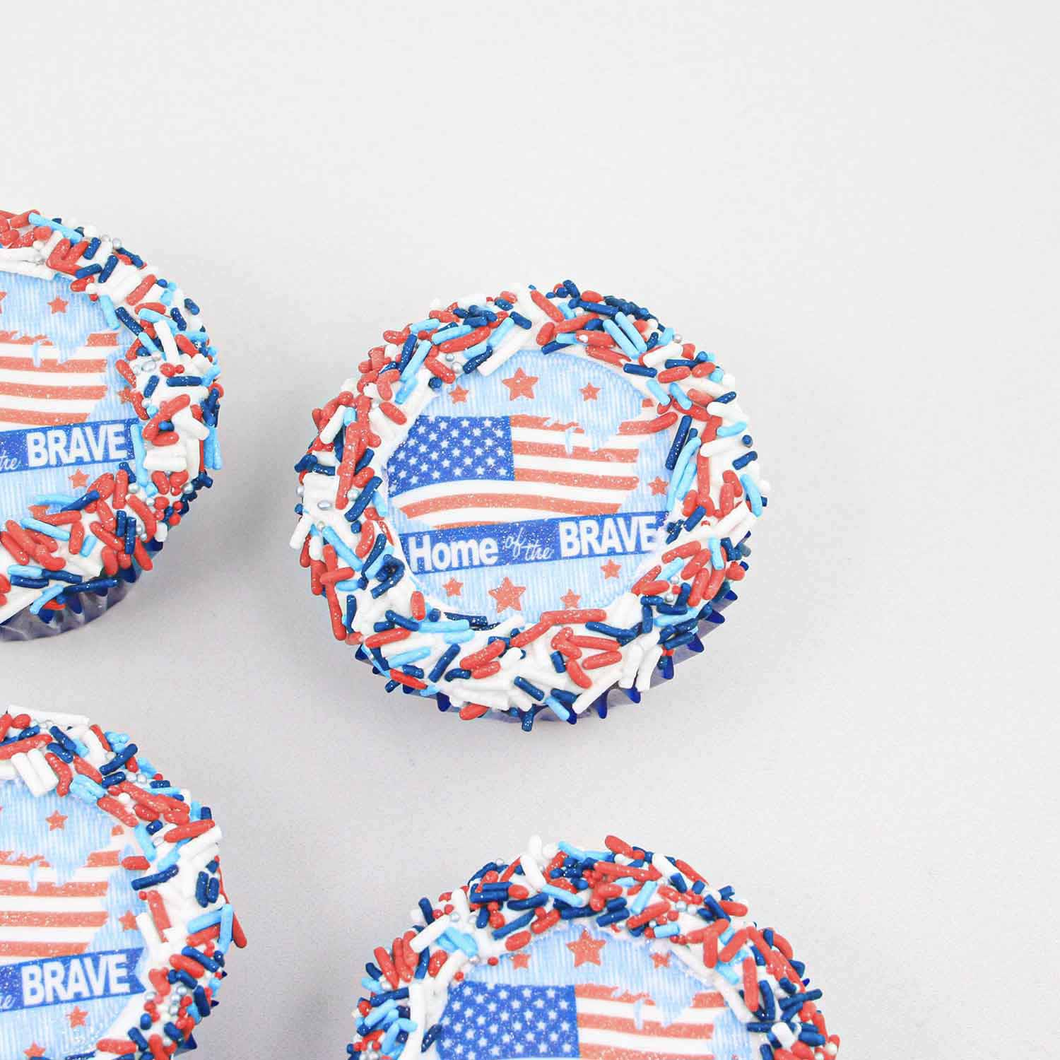 Patriotic edible image cupcake topper surrounded by buttercream and red white and blue jimmies