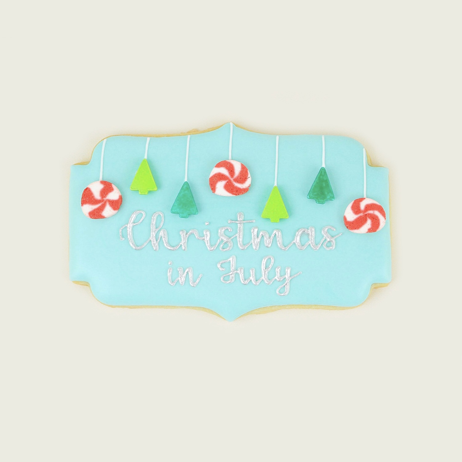 Christmas in July Cookie Plaque decorated in royal icing and adorned with Christmas candy lights and ornaments.