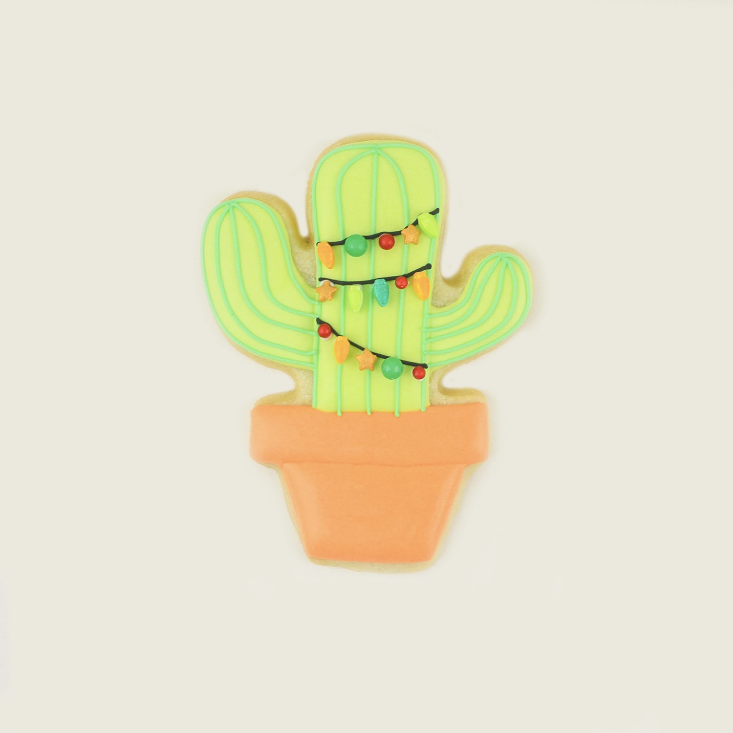 Royal icing cactus cookie adorned with Christmas lights