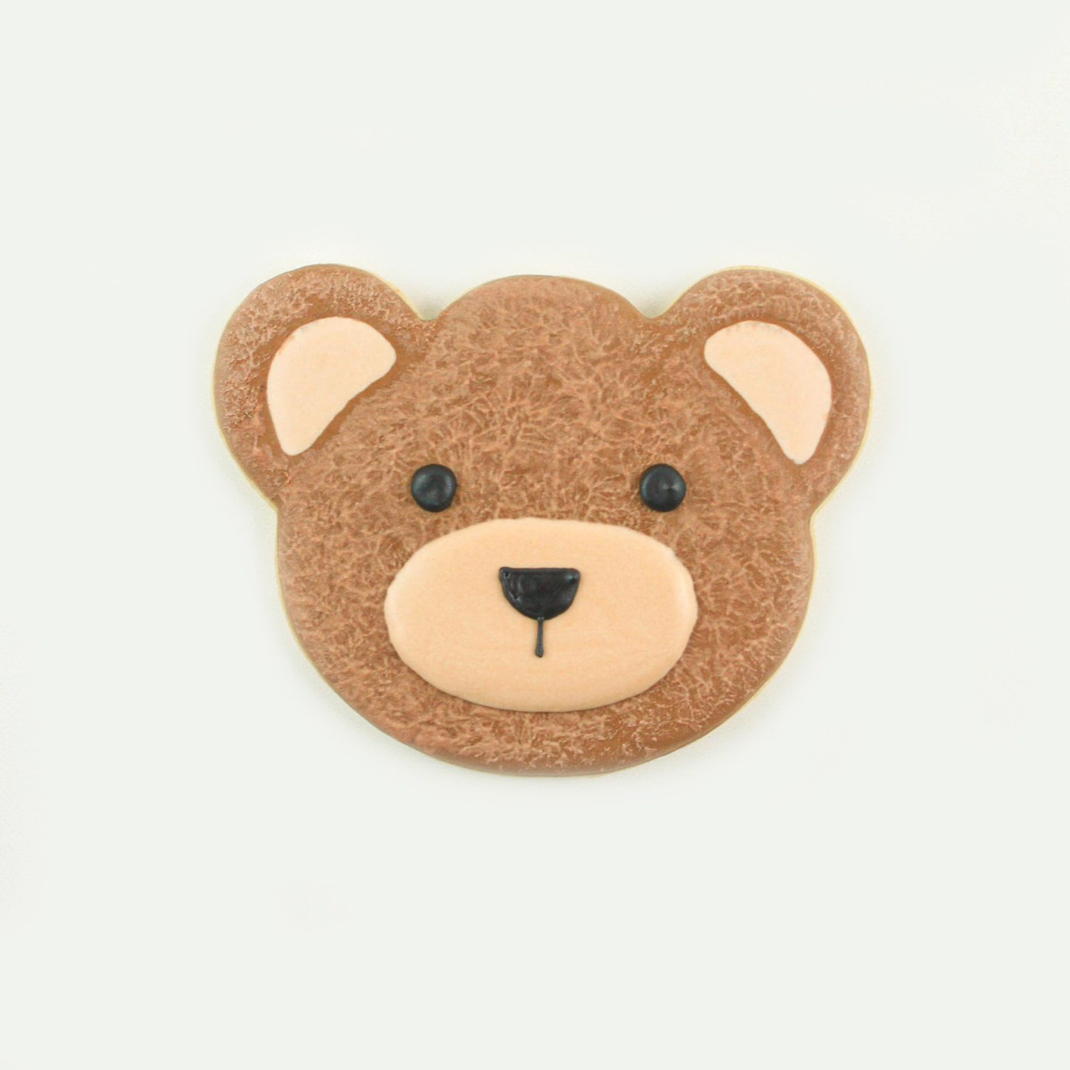 Bear face cookie in brown royal icing and with ivory icing dabbed all over face for a fur texture.