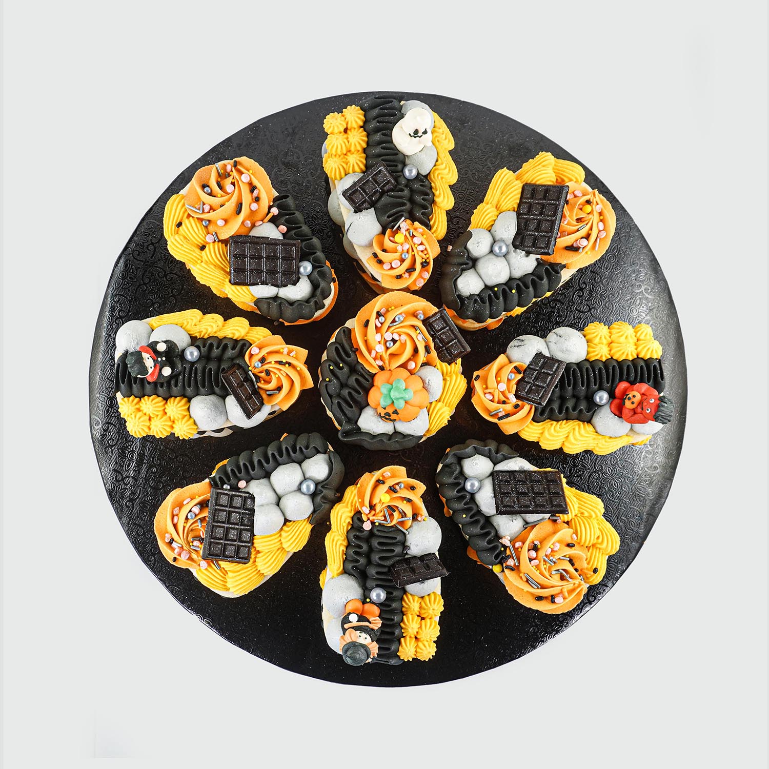 Halloween Layered Buttercream Cookie Pizza iwth yellow, pumpkin, slate and black piped buttercream with chocolate bars,sprinkles and halloween theme sugar layons