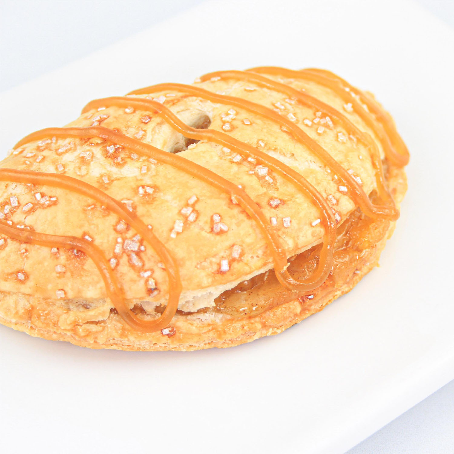 Caramel Apple Pie Pocket showing the drizzled caramel and sugar crystals embellishing the surface of the pocket pie