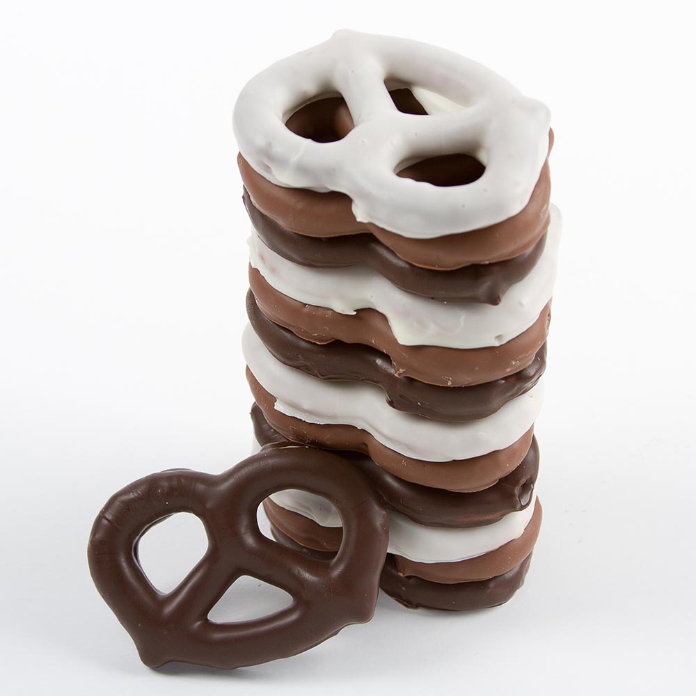 a stack of large pretzels dipped in white, milk and dark chocolate