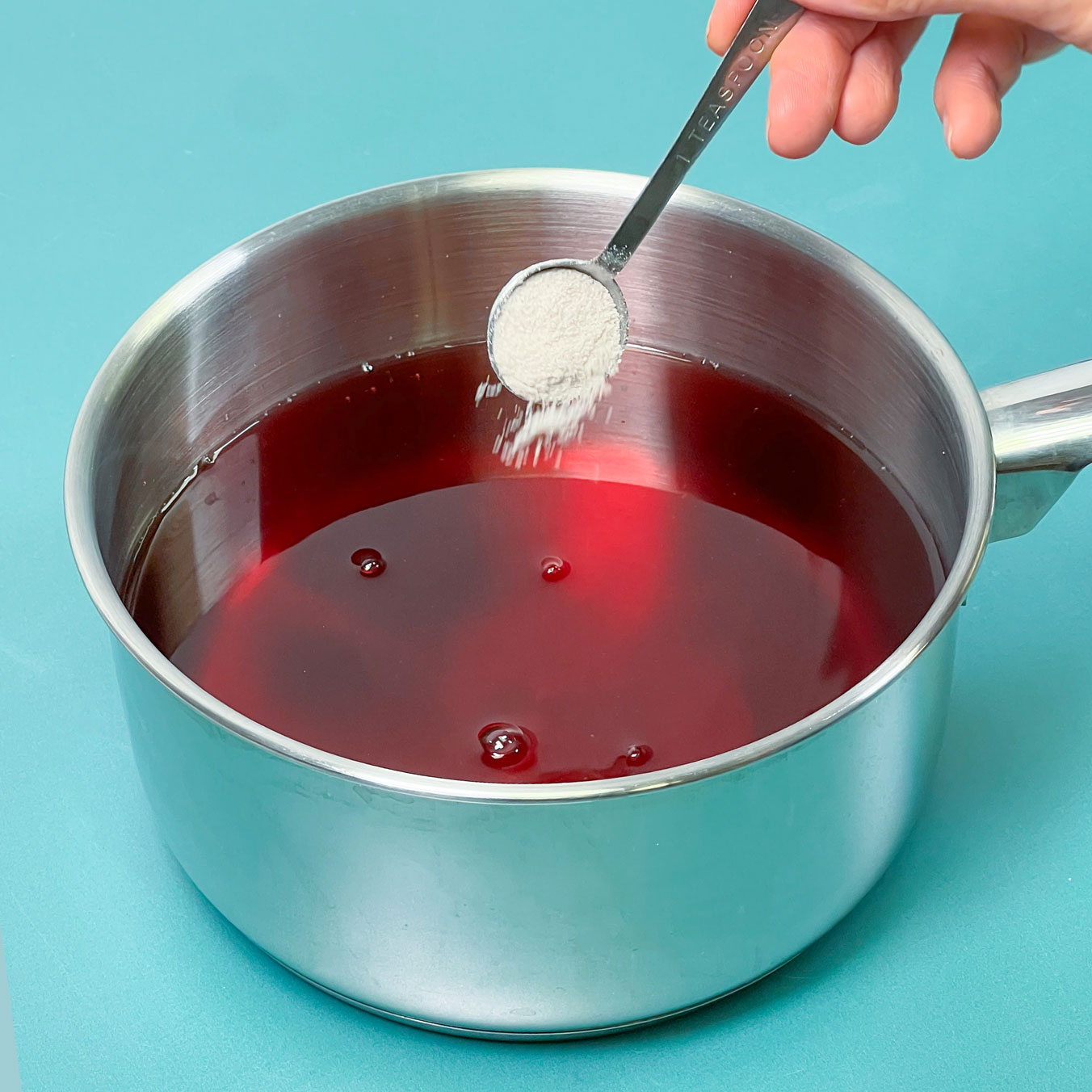 adding aspen mulling spices into saucepot