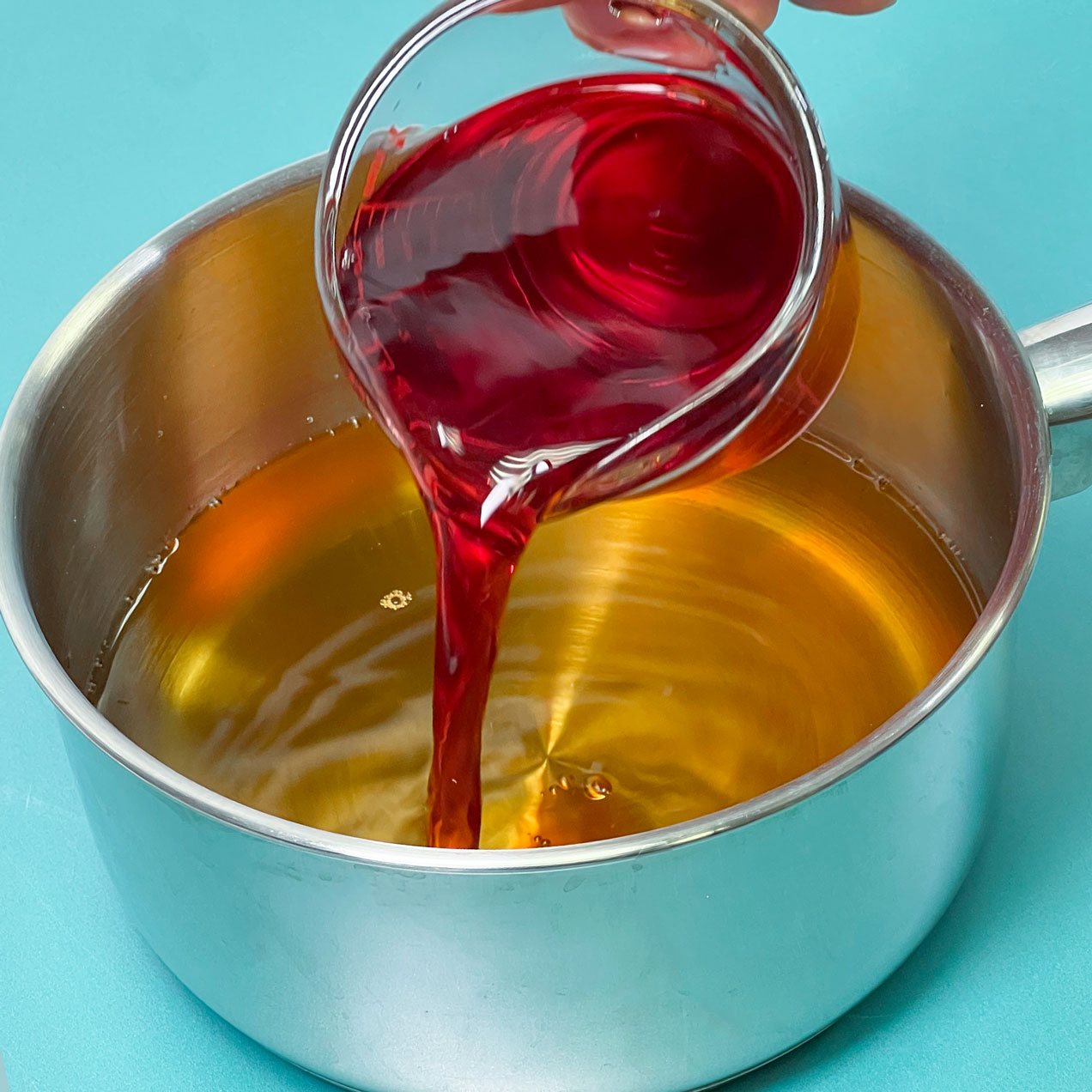 pouring cranberry juice into saucepot