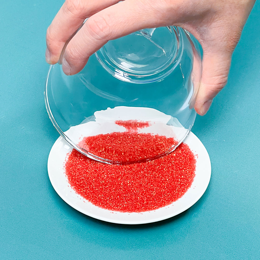 rimming glass in red sanding sugar