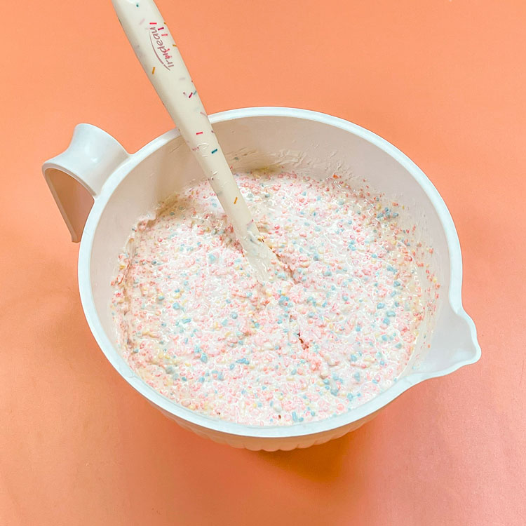 bowl with melted white chocolate and birthday crunch mixed