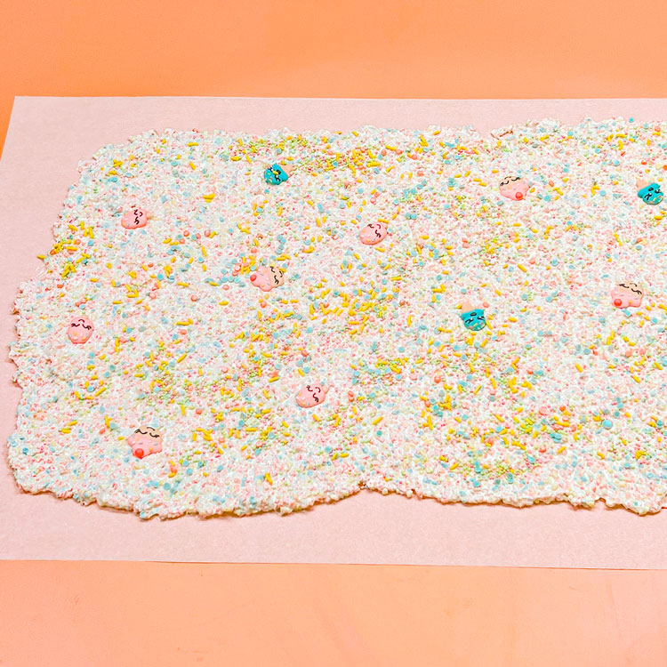 chocolate mixure poured onto parchment and decorated with sprinkles
