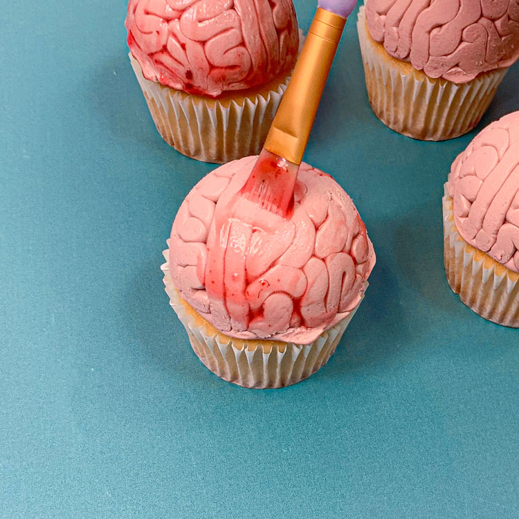 painting fake blood onto brain cupcakes