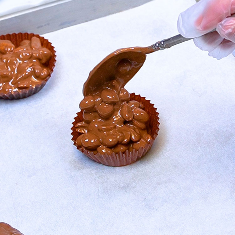 assembling chocolate peanut mound in large candy cup