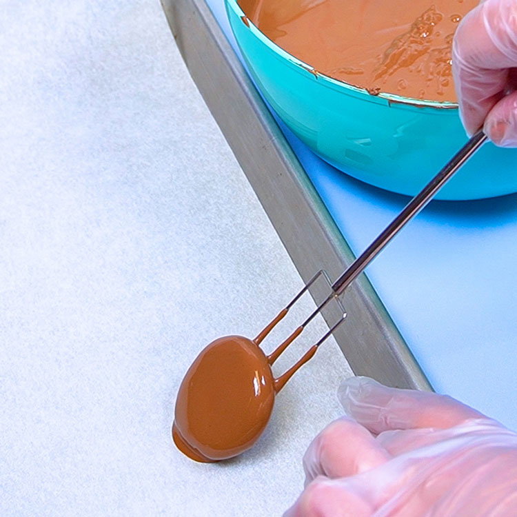 placing dipped candy center patty onto parchment paper