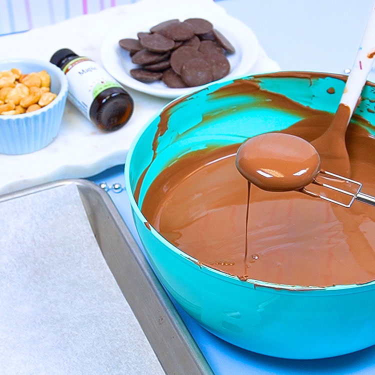 dipping vanilla dry fondant patty into melted milk chocolate