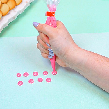 pink chocolate circles piped onto parchment paper